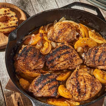 Grilled chickenhearted  thighs with peaches and onions successful  a cast-iron skillet, showcasing a rustic, home-cooked meal. Perfect for a cozy meal  setting