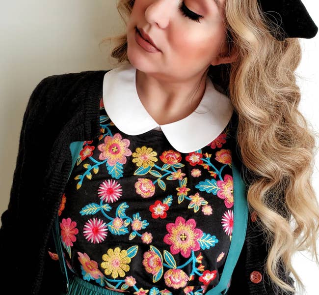 Model is wearing an embroidered sweater and a white peter pan collar