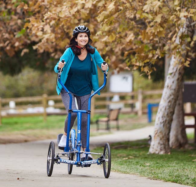 Model is riding the blue elliptical bike