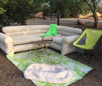 Reviewer image of product outside with blanket on top of it next to a folding chair and blanket