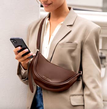 Woman with a crossbody bag looking at her phone