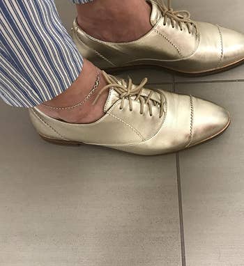reviewer wearing the gold oxfords with striped pants