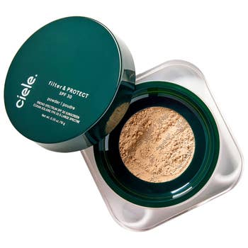 Compact instrumentality  of ciele filter & PROTECT SPF 30 pulverization  with sunscreen, featuring the product's unfastened  lid and pulverization  design