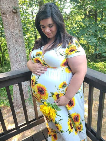 reviewer posing wearing sunflower print dress