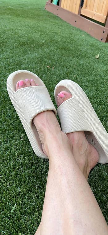 reviewer wearing beige slide sandals 