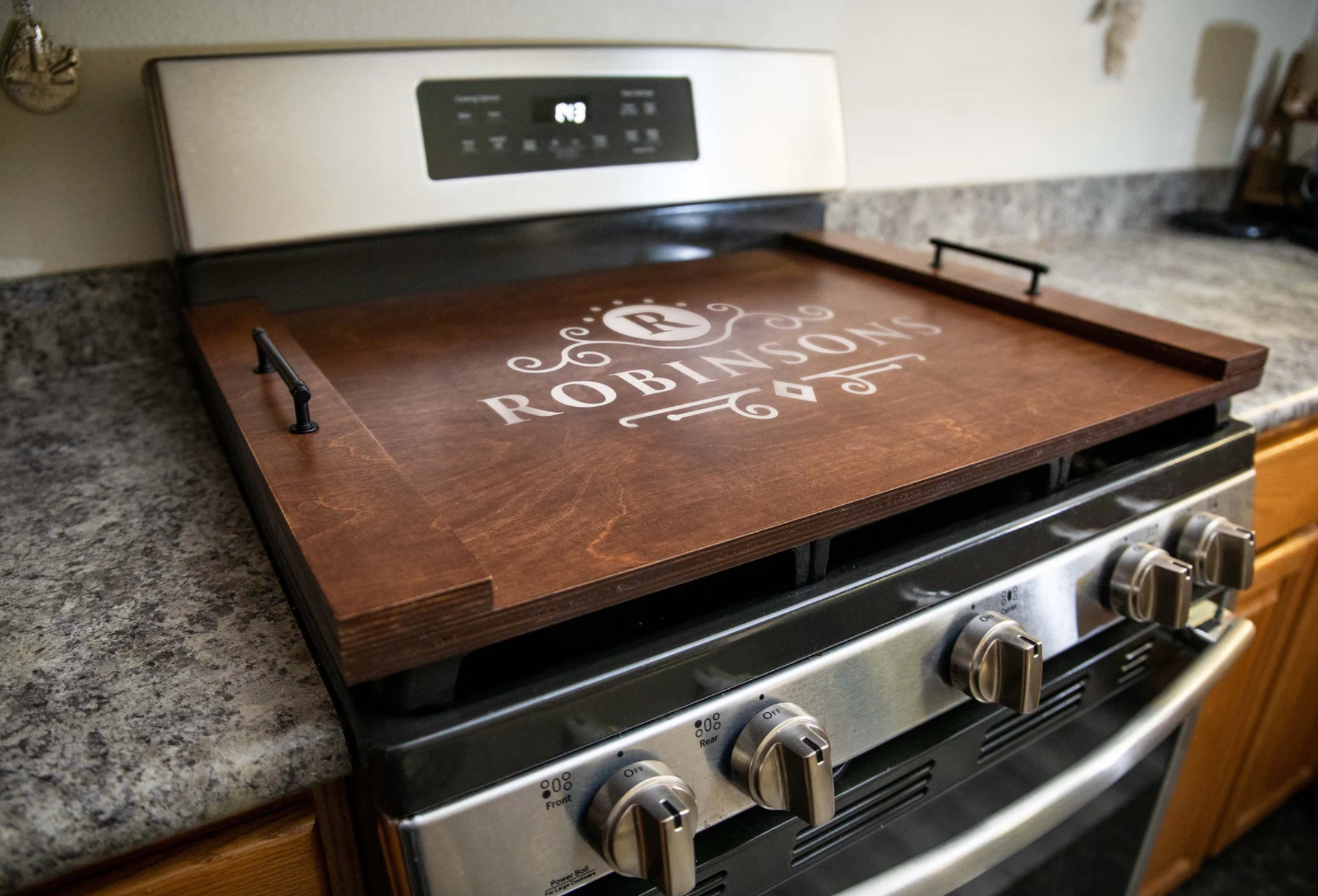 stove with a dark wood stovetop cover with handles on top of it