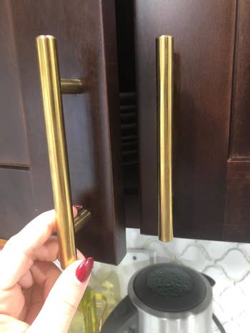 The reviewer opening their cabinet with the gold handle