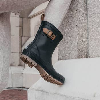 Instagram photo of model wearing mid-calf buckle rain boots