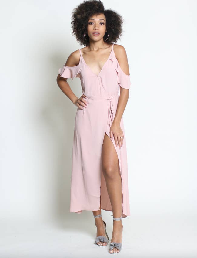 model wearing pink maxi wrap dress with cold shoulders and a leg slit