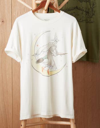 the white graphic tee with a skeleton witch on a broom