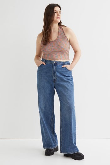 model wearing multicolored ribbed halter tank top and jeans