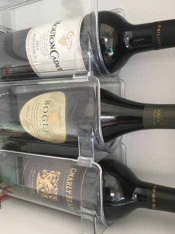 reviewer's shelf with three wine bottles in tiered organizer