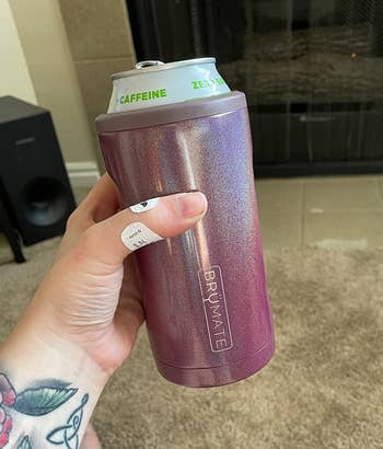 Reviewer holding glittery purple drink cooler with a can in it 