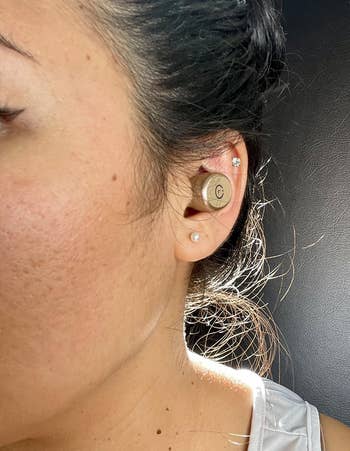 reviewer wearing the khaki earbud in one ear