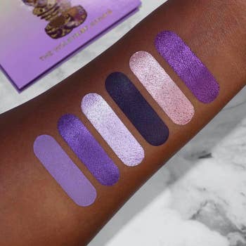 model's arm showing swatches of the purple eyeshadows