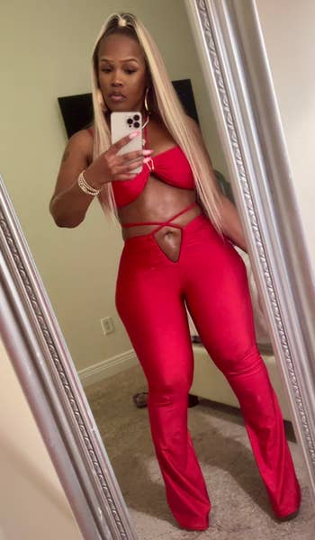 Person successful a stylish cut-out outfit takes a selfie successful a mirror, showcasing their manner choice