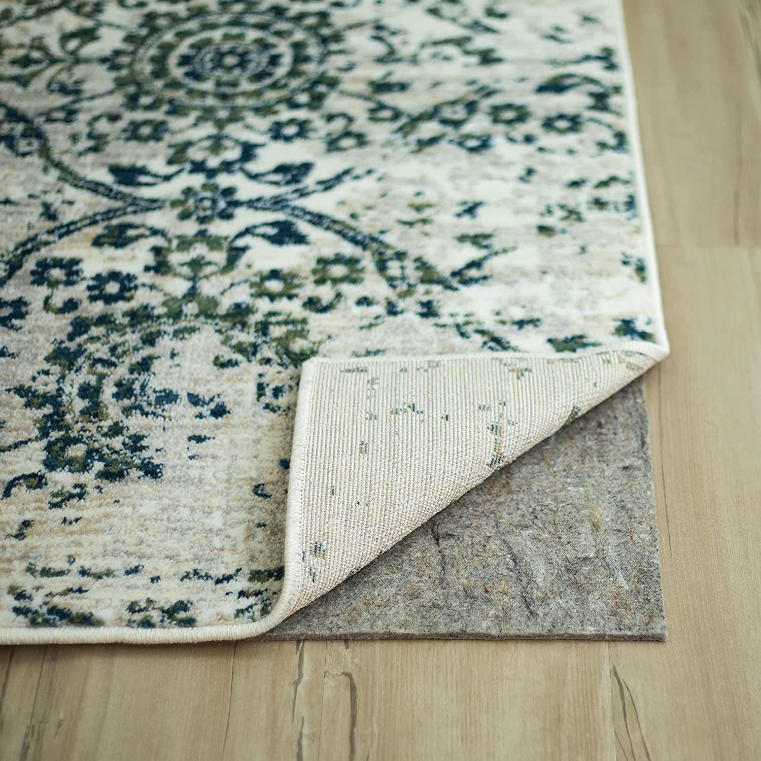 a gray felt rug pad underneath a larger rug