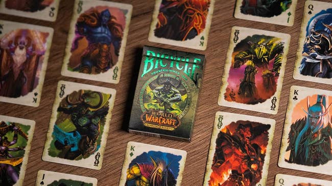 Deck of World of Warcraft themed playing cards spread out on a wooden surface