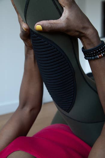closeup of the leggings in green, showing the pads on the knee