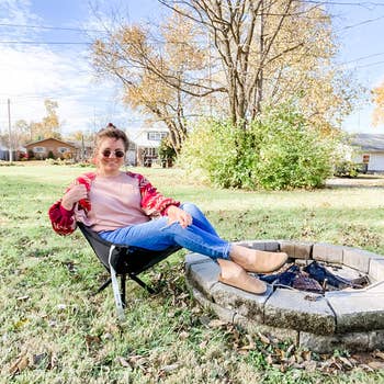 reviewer in cliq camping chair next to fire pit