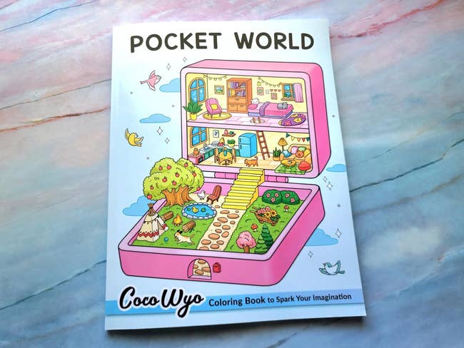 Cover of 'Pocket World' coloring book by Coco Wyo with whimsical house and garden illustrations