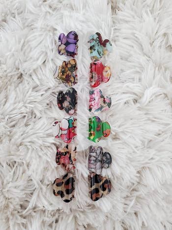 reviewer photo of the set of 12 multicolor clips on a white carpet
