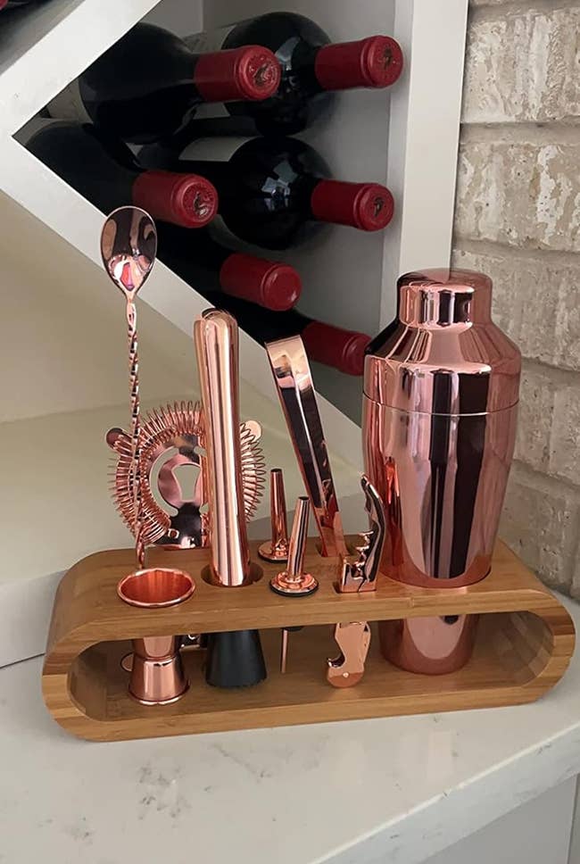 copper mixology utensils in a wooden stand