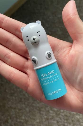 The small polar bear shaped eye stick in a reviewer's hand 
