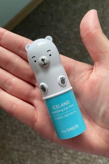 The small polar bear shaped eye stick in a reviewer's hand