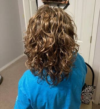 reviewer seen from behind showcasing curly hairstyle