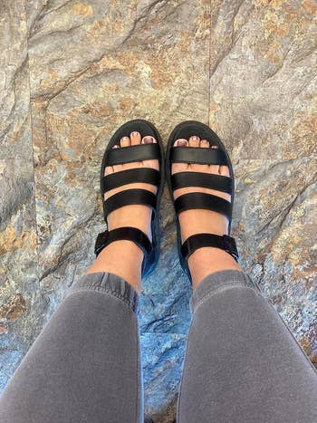 Person wearing achromatic  strappy sandals 