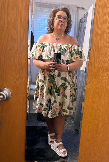 Person successful floral off-shoulder formal taking a reflector selfie successful a bathroom
