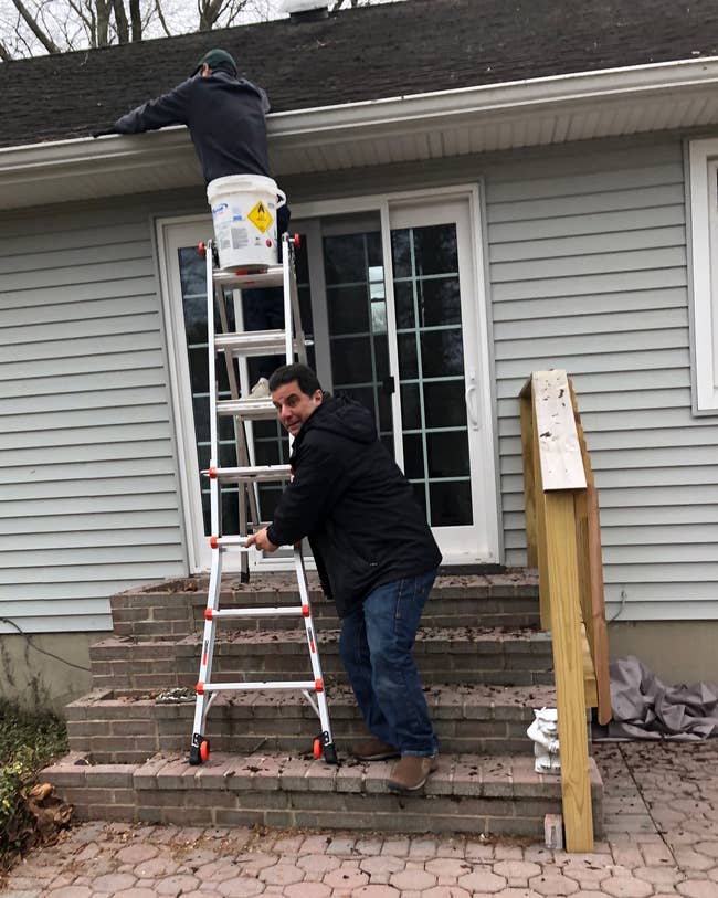 the editor's husband cleaning out their gutters while her father-in-law holds the ladder