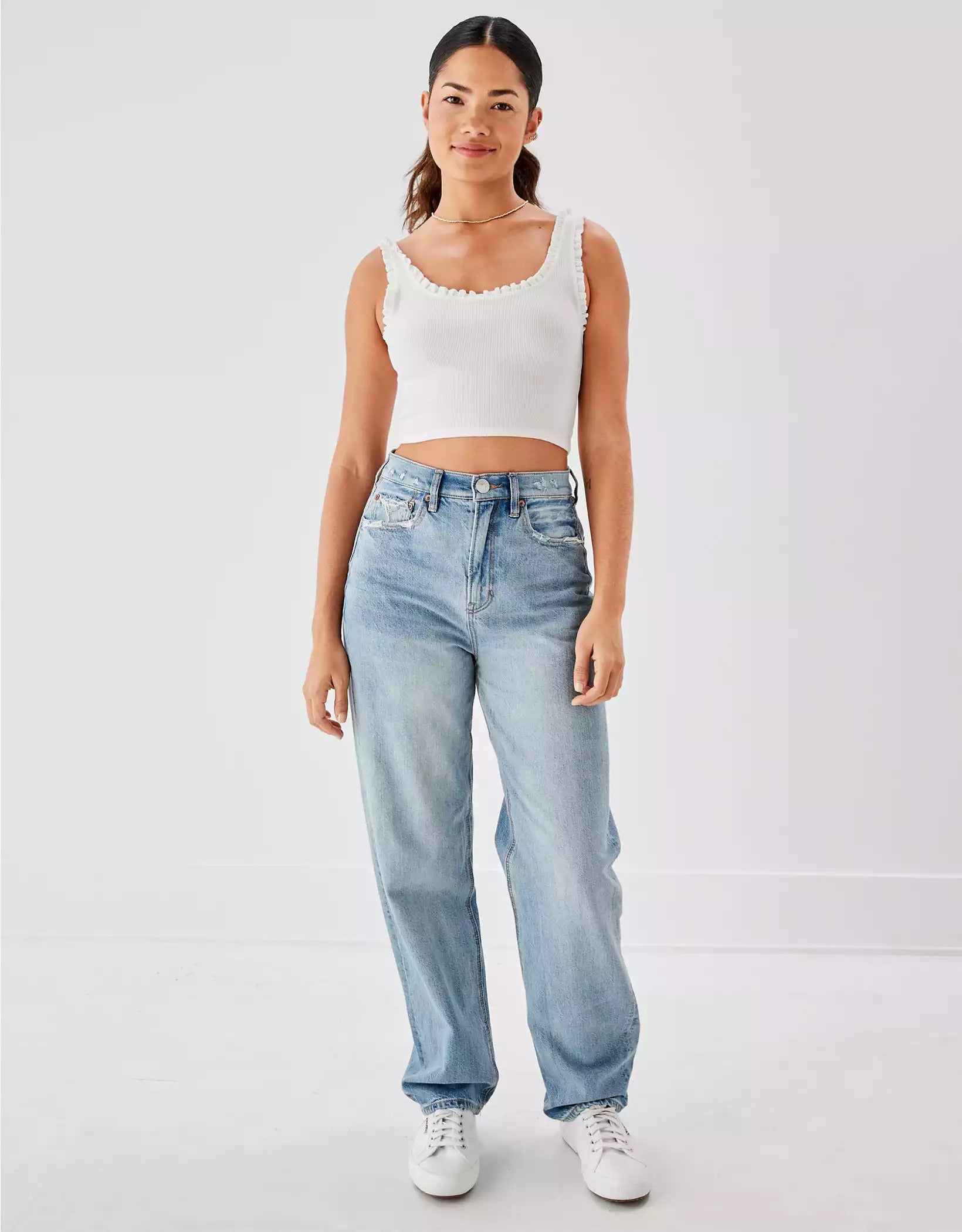 model wearing the light wash denim high waisted baggy jeans with a crop top