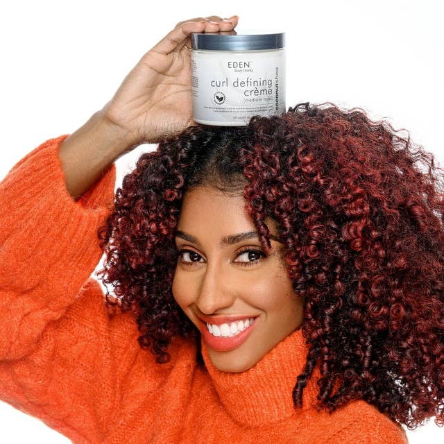 the model with curly hair holding the product on top of her head