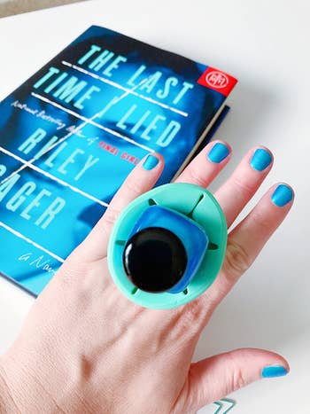 Reviewer image with the mint green grip on their finger with nail polish in it showing their nails