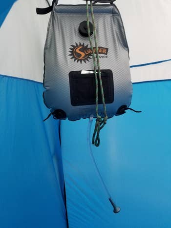 a reviewer photo of the shower hanging up inside of a portable tent