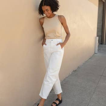 a model poses in the white pants