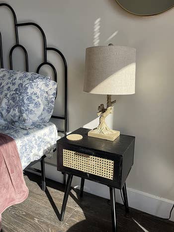 reviewer photo of black nightstand with rattan drawer