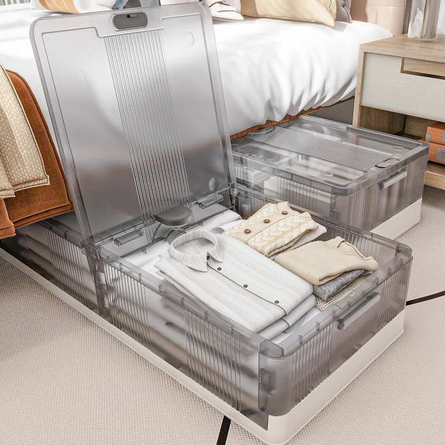 Clear under-bed retention boxes filled with neatly folded clothing, illustrating businesslike enactment for maximizing chamber space