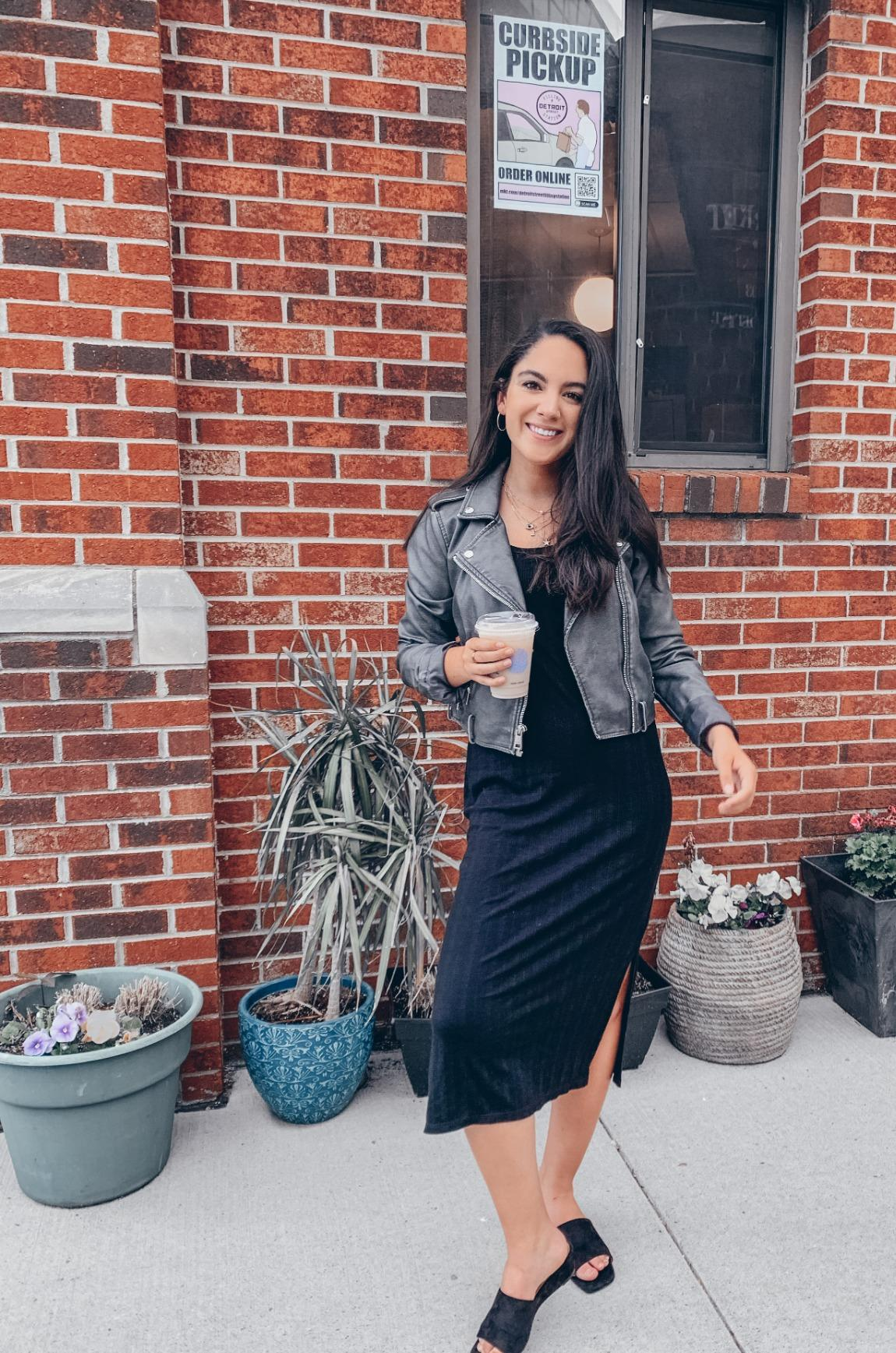 a reviewer wearing the coat with a black dress