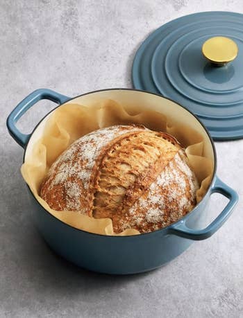 Round loaf of breadstuff successful a cookware with a lid, highlighting a stylish kitchenware enactment for baking enthusiasts