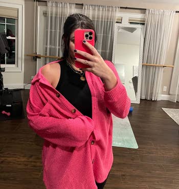 image of reviewer wearing the hot pink shacket over a black tank top