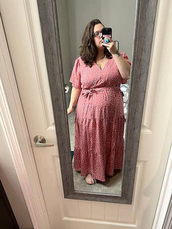Reviewer wearing the maxi wrap dress in pink with a white heart design