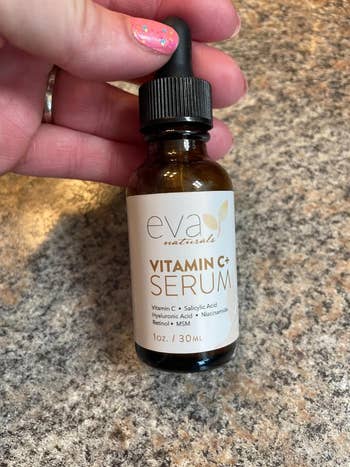 image of reviewer holding the bottle of serum