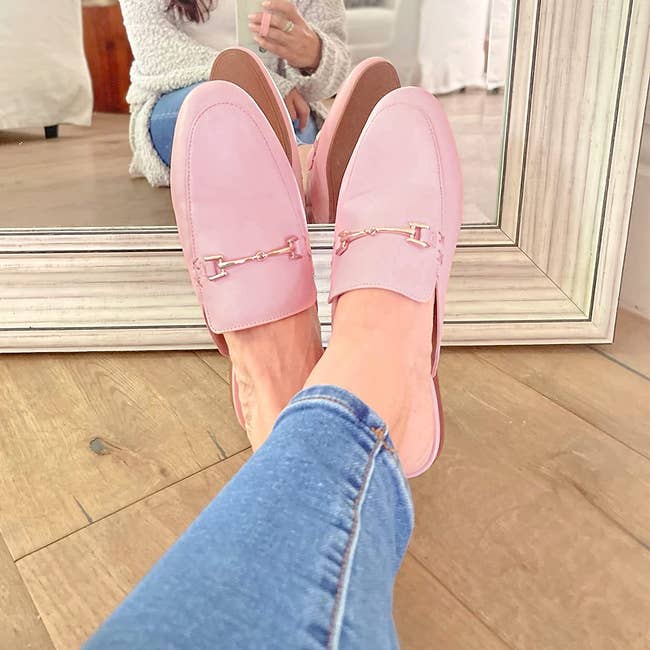 model in pink mule flats with gold buckle