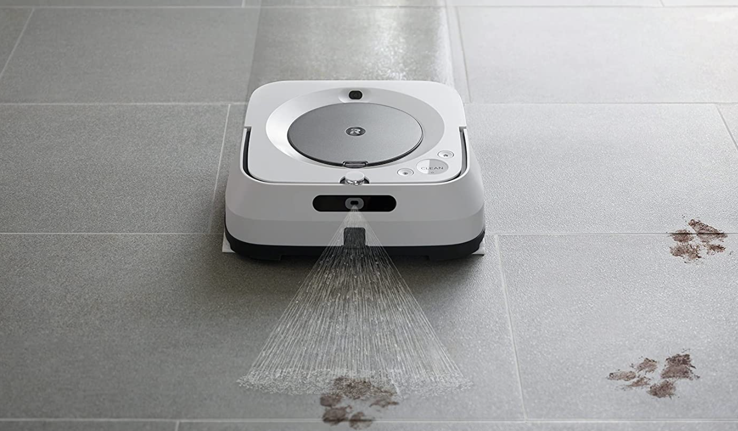 The iRobot vacuum spraying a cleaner on a floor covered in muddy prints
