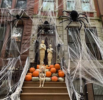 spider web decoration draped outside of brownstone apartment front stoop