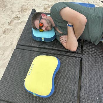 reviewer laying connected bluish inflatable pillow