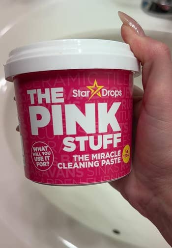 a hand holding a jar of the pink stuff